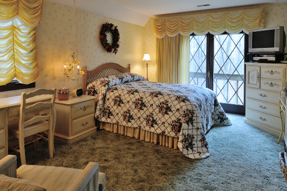 bedroom with yellow designed fabric and sun shining in room